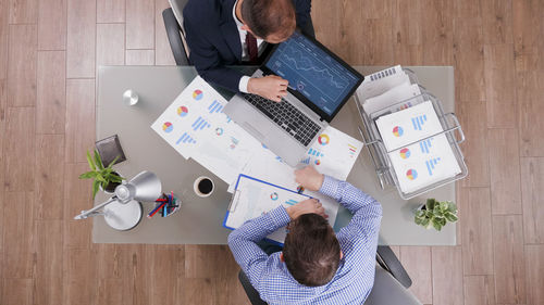 High angle view of people using laptop on table