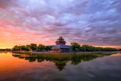 Reflection of building in lake at sunset