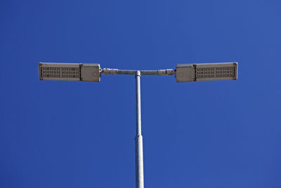 Low angle view of street light against blue sky