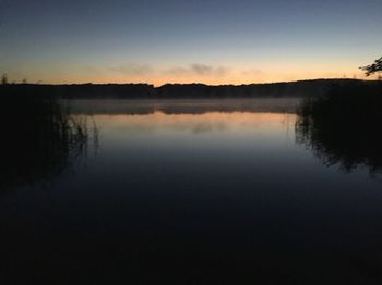 Scenic view of calm lake at sunset