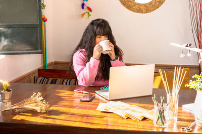 Young woman using laptop at table