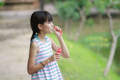 Girl blowing bubble at park