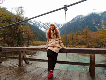 Beautiful model in a stylish winter outfit  with a  mountain landscape behind her in japan alps