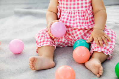 Midsection of baby girl playing with toy