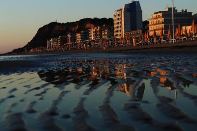 Panoramic shot of sea and buildings against sky at sunset
