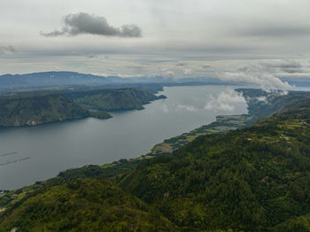 High angle view of sea and mountains against sky