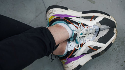 Low section of man wearing multi colored shoes
