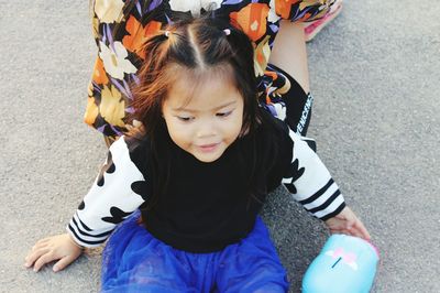 High angle view of cute girl sitting against woman