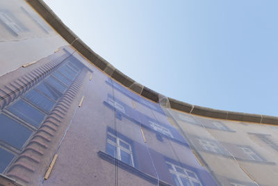 Facade of multi-family house under restoration covered with nets