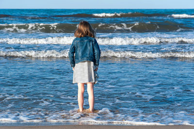 Rear view of girl standing in sea