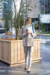 Portrait of young woman standing in city