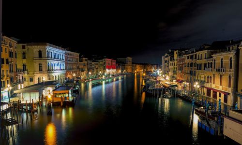 Boats moored in canal at night