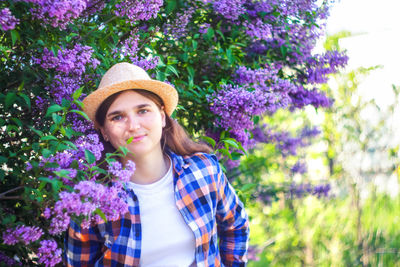 Spring allergy. defocus beautiful young woman near blooming spring tree. bush lilac flowers. youth