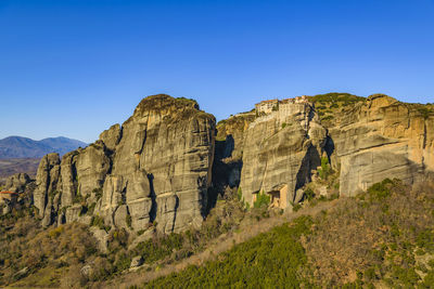 Rock formations on mountain against clear blue sky