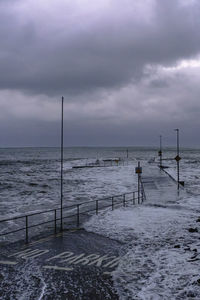 A storm and high sea floods a pier. located on the wild atlantic way in kerry, ireland.