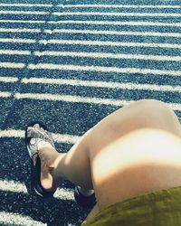 Low section of woman relaxing on road