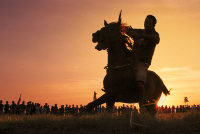 Silhouette statue against sky during sunset