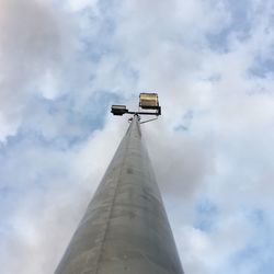 Low angle view of communications tower against cloudy sky