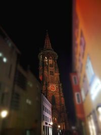 Low angle view of illuminated clock tower at night