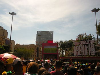 People on street in city against sky