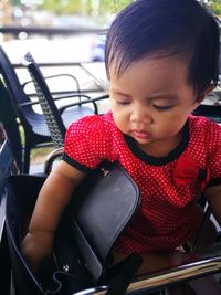 Close-up of cute baby girl with purse