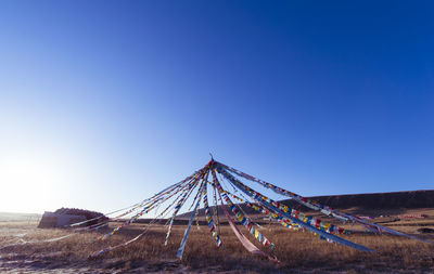 Built structure on landscape against clear blue sky