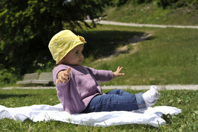 Side view of girl sitting on grass