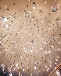 Low angle view of illuminated chandelier hanging on ceiling