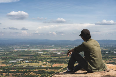 Man looking at cityscape against sky