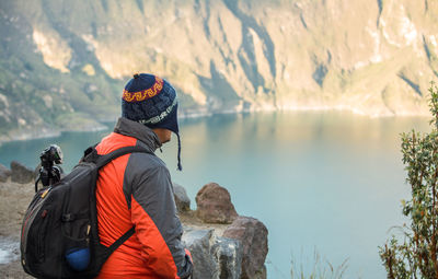 Rear view of person looking at mountain during winter