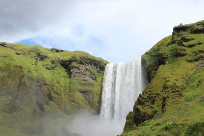 Scenic view of waterfall against sky