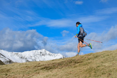 Man jumping in mountains against sky