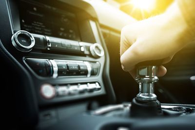 Close-up of man hand on gearshift in car