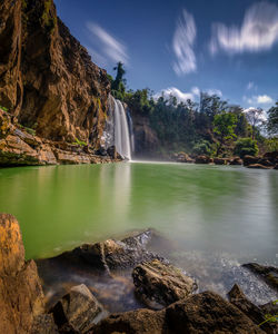 Scenic view of waterfall against sky