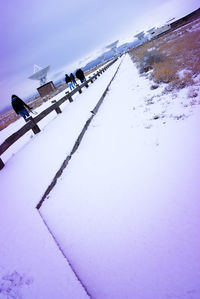 Ski lift on snow covered mountain against sky