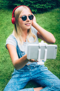 Young woman using mobile phone in grass