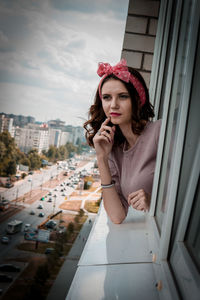 Portrait of young woman looking at city