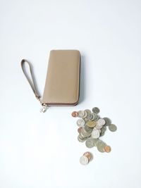 High angle view of coins on table against white background