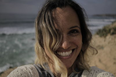 Close-up of portrait of smiling young woman at beach
