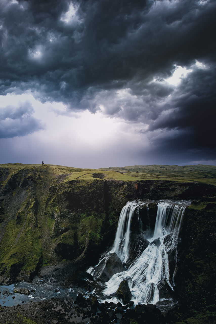 SCENIC VIEW OF WATERFALL AGAINST SKY DURING SUNSET