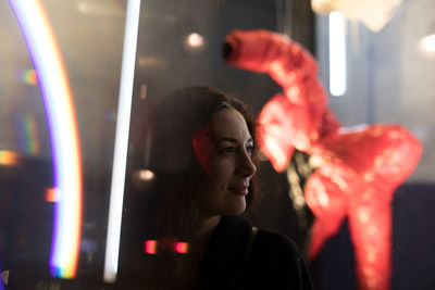 Close-up of thoughtful woman standing against window