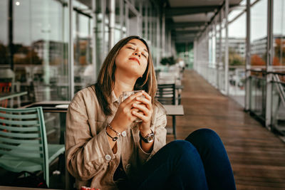 Mexican woman enjoys morning coffee on terrace of cafe. mental health, wellness and slow living