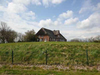 Barn on field against sky