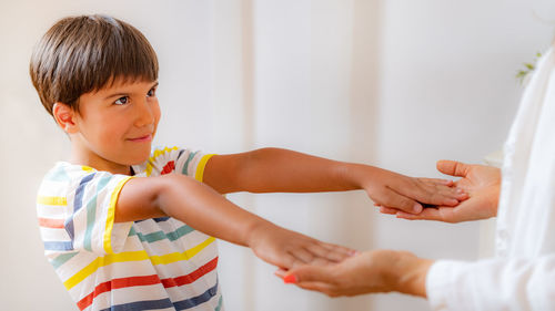 Physical medical exam for children. physical therapist doing medical exam, boy holding arms raised