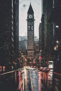 Wet street amidst buildings in city during rainy season