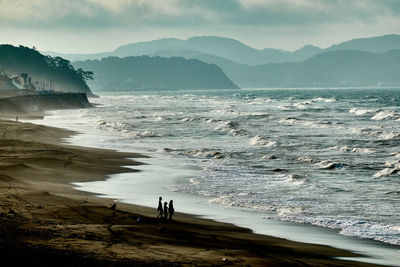 Scenic view of sea and mountains against sky