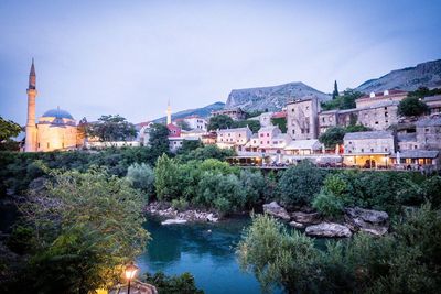 River amidst buildings in town against sky