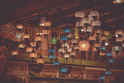 Low angle view of illuminated lanterns hanging in store