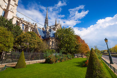 View of trees and building against cloudy sky