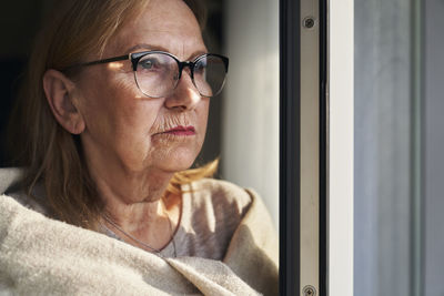 Portrait of young man looking through window